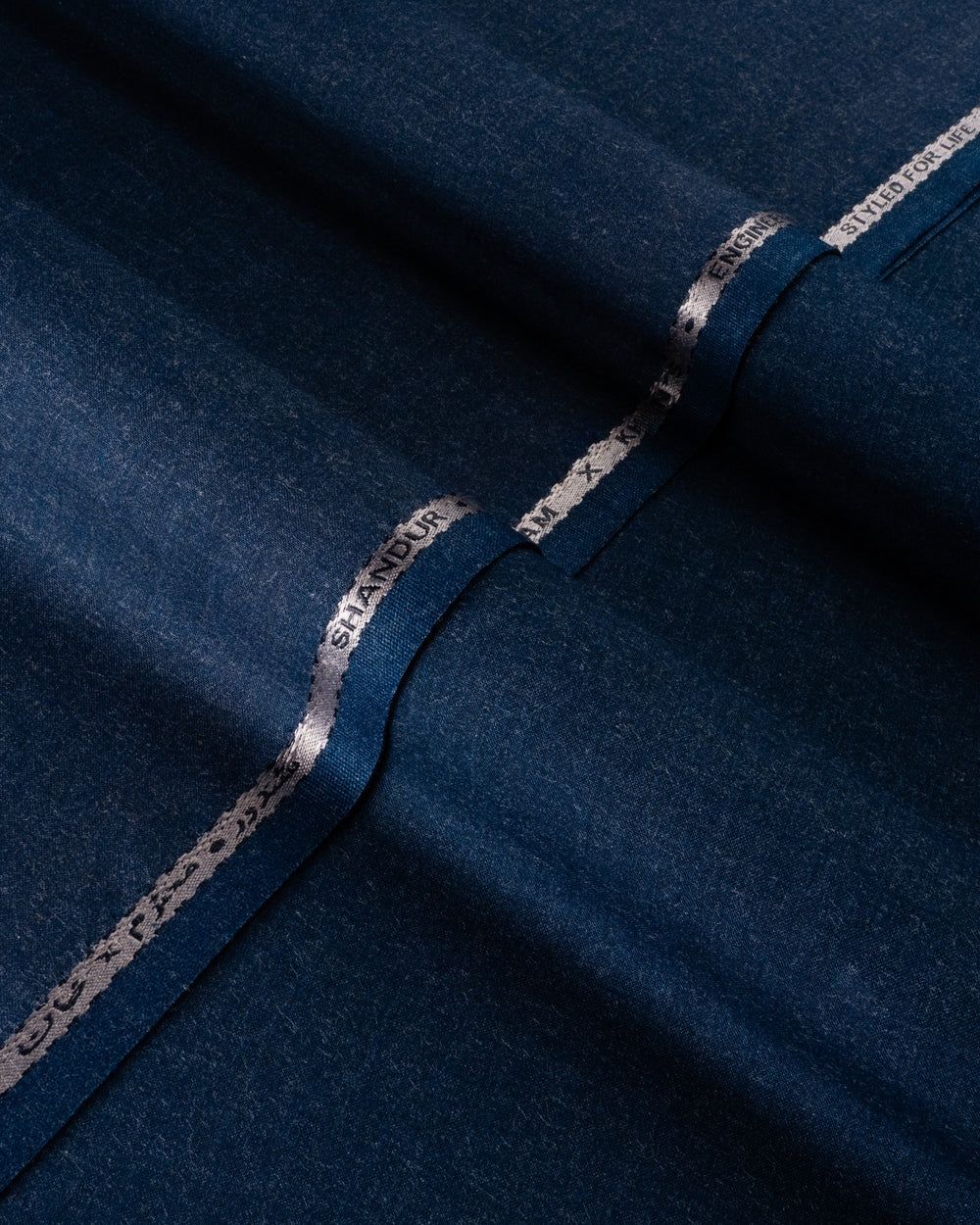Close-up of dark blue fabric with 'Slanders' branding.