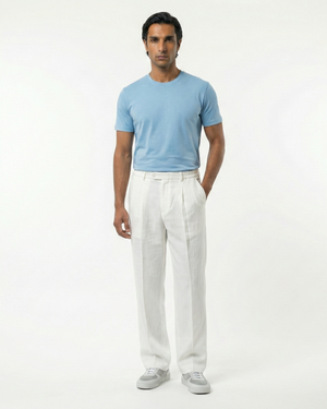 Man wearing a light blue shirt and white pants on a white background
