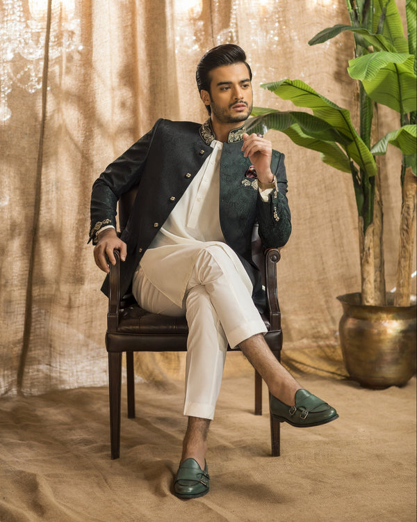 Man sitting in a chair in a room with plants and a chandelier
