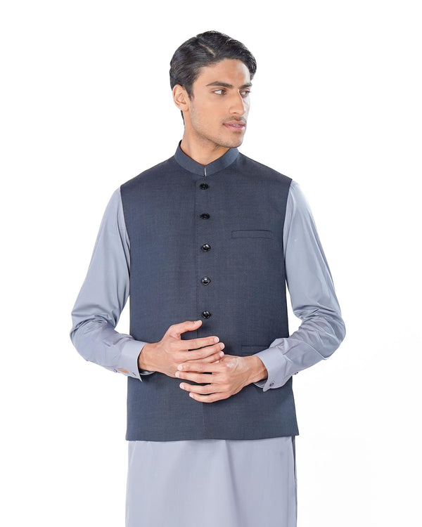 Man wearing a traditional outfit with a vest and kurta on a white background