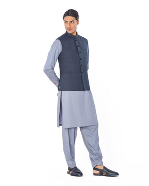 Man wearing a traditional outfit with a vest and kurta on a white background