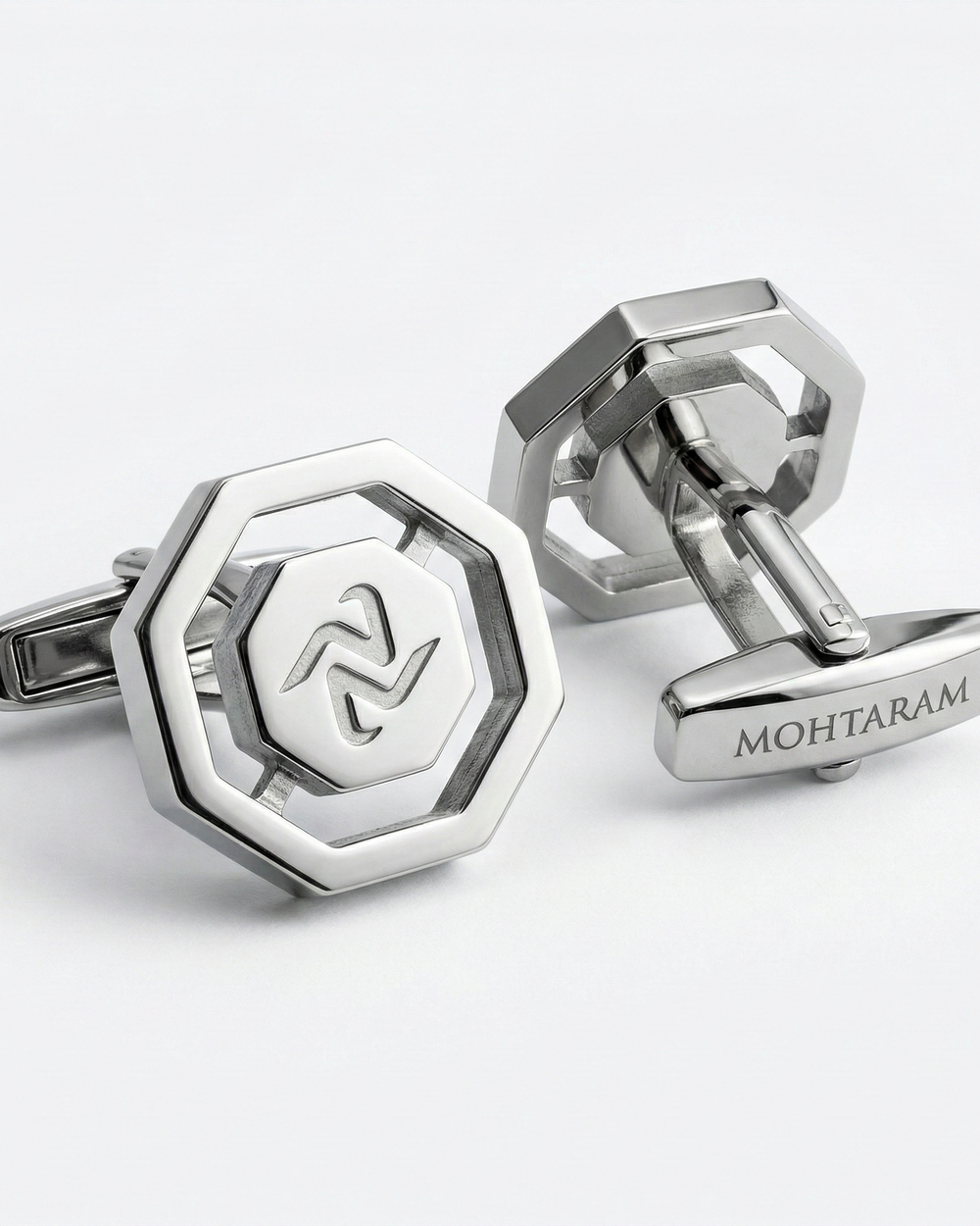 Silver cufflinks with a hexagonal design and 'MOHTARAM' branding on a white background