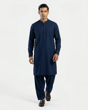 Man wearing a navy blue kurta with pants on a white background