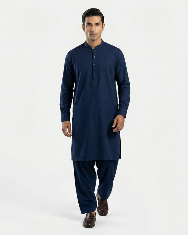 Man wearing a navy blue kurta with pants on a white background