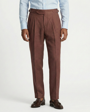 Brown dress pants worn with a light blue shirt on a white background