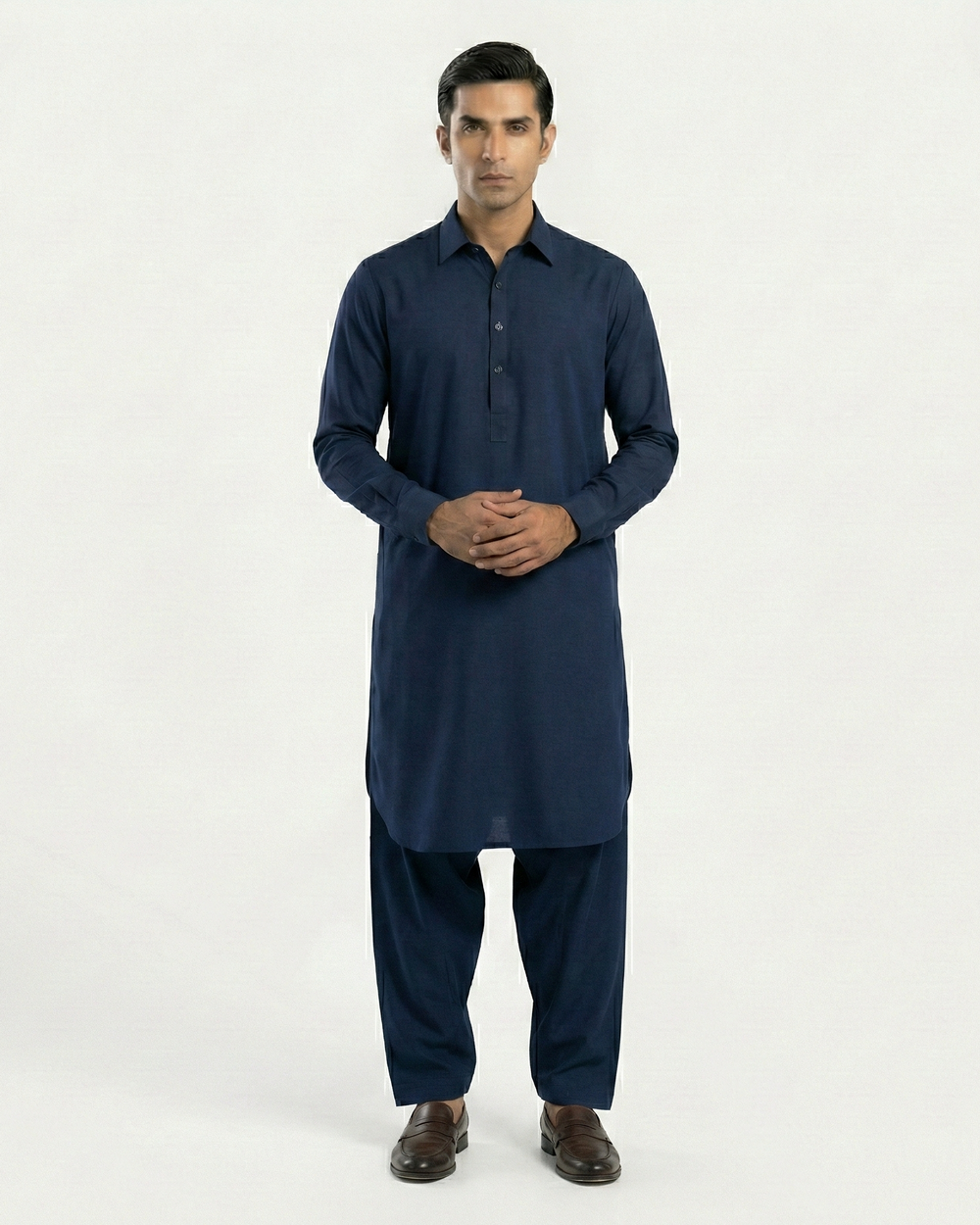 Man wearing a navy blue kurta with pants on a white background