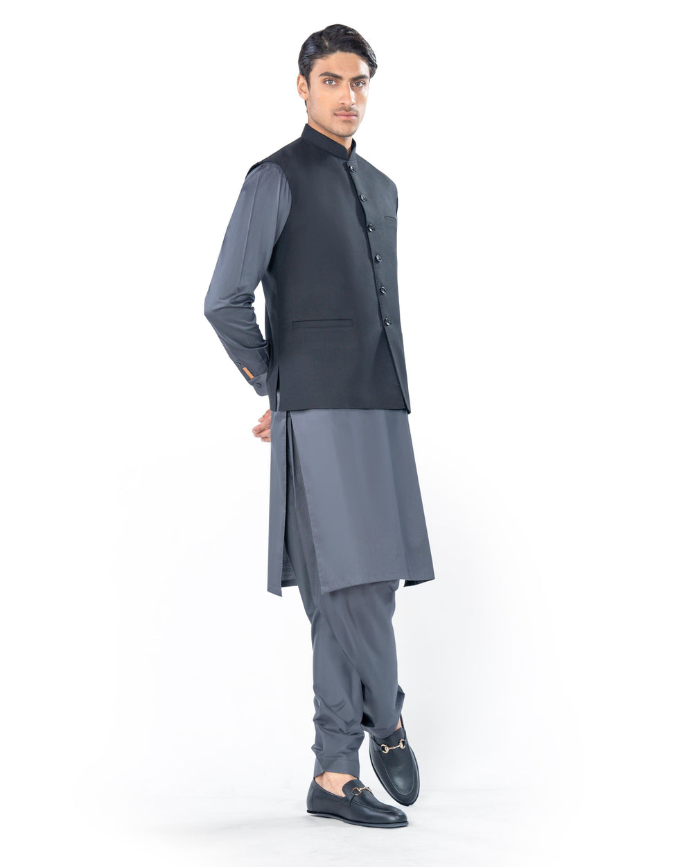 Man wearing a traditional outfit with a black vest and gray kurta on a white background