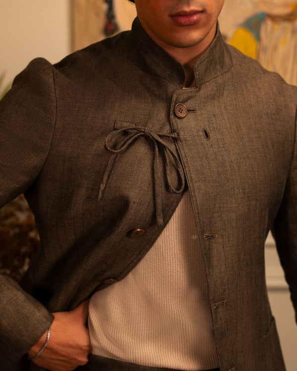 Mohtaram – Close-up of the mandarin collar, cord tie and brown herringbone linen