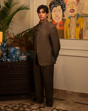 Mohtaram – Convertible suit with the jacket buttoned to a mandarin collar and cord tie